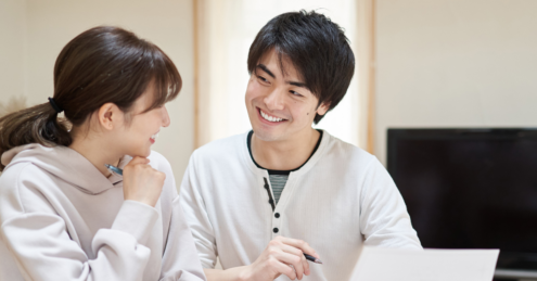 a couple, man and woman, sitting together in their home looking over documents, the woman has her head in her hand as she is thinking, thinking about if she should remortgage after her fixed rate mortgage ends.